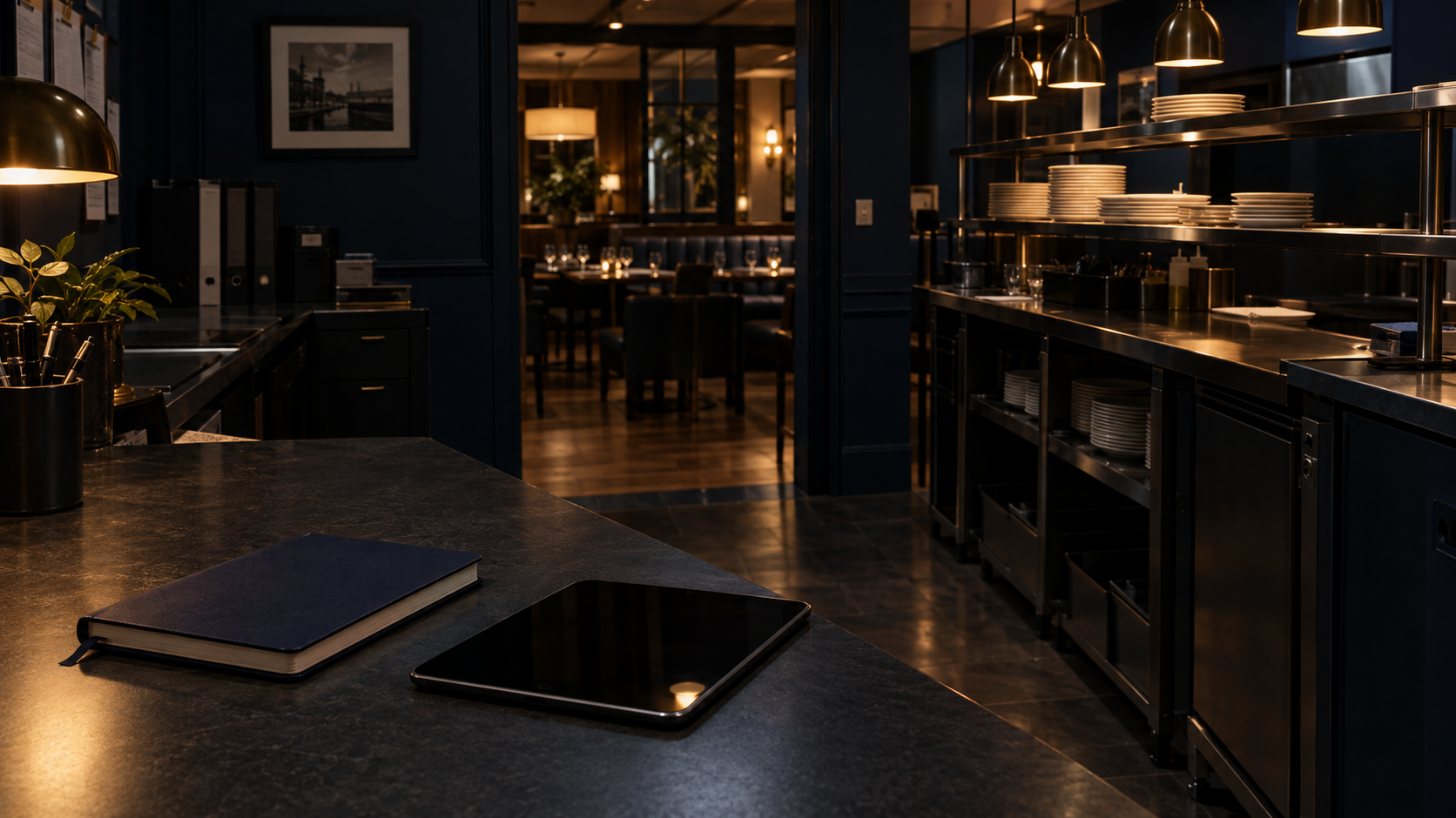 An empty restaurant service station with a notebook and unmarked tablet nearby.